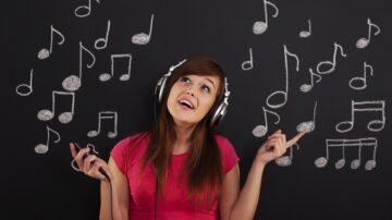 Happy woman listening to music through headphones