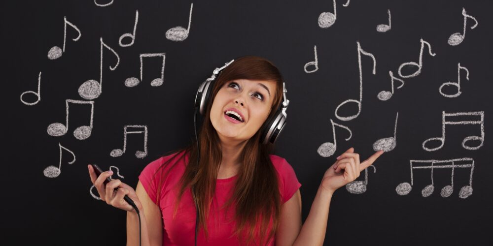Happy woman listening to music through headphones